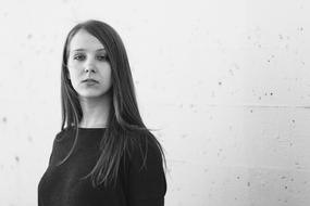 monochrome portrait of a girl with long hair on a white wall background