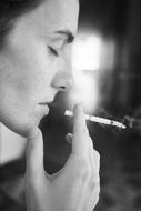 woman with a cigarette in profile on a blurred background