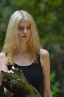 Young slim blonde girl at greenery