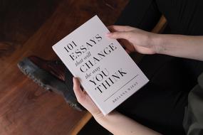 Black text on the white book, in the hands of the woman