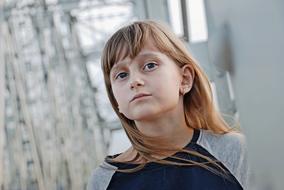 serious caucasian young girl looking up