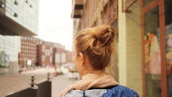 Back view of a blonde girl, walking near the Westerdok in Amsterdam, Netherlands