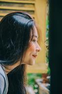 Profile portrait of a smiling woman, looking out of the window
