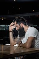 Bearded young caucasian man at table