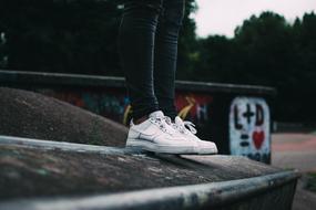 photo of girls legs in white sneakers