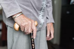Old woman with the beautiful and colorful, wooden cane