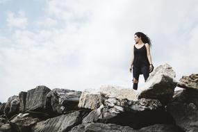 photo of a girl on a pile of cobblestones
