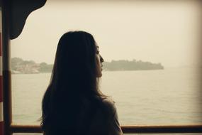 the girl looks at the sea in the deck of the ship