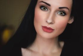 Portrait of the beautiful woman with the colorful make-up, at blurred background