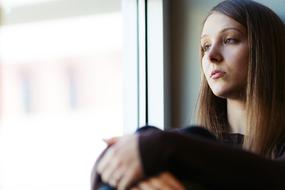 Portrait of the girl in light, sitting near the window