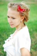 blonde with a butterfly in her hair on a summer meadow on a blurred background