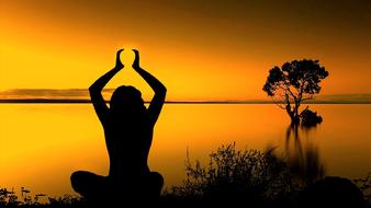 meditation pose near the water at dusk
