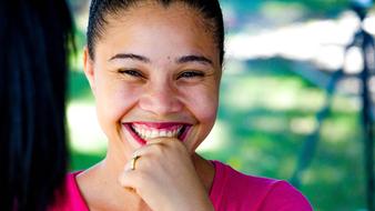 smiling girl in pink t-shirt ana blurred background