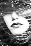 female face behind transparent plastic, black and white