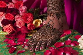 Foot with the beautiful Mehndi designs, in the colorful flowers