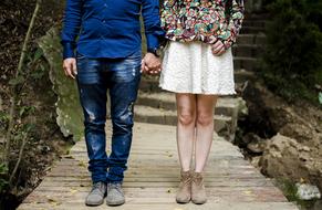 feet of young couple on boardwalk in nature