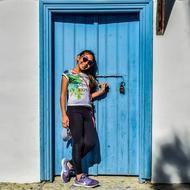 girl in sunglasses near wooden blue door
