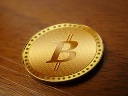 gold bitcoin coin on wooden table