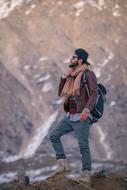 stylish man with a backpack in the mountains