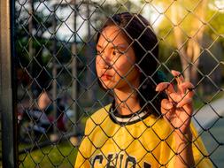 Woman behind metal fence