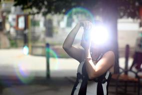 Woman in black and white dress taking a photo with flash