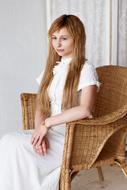 woman posing in wicker chair