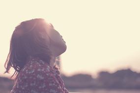 Sad girl in sunlight, at blurred background