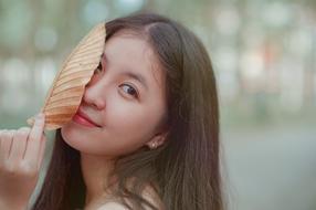 photo of a girl with an autumn leaf on her face