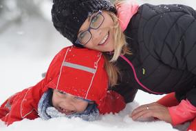 photo of mom and baby lying in the snow