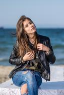 young woman in leather jacket on the beach