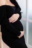pregnant woman in black dress close-up