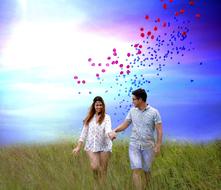 Happy couple on the field at colorful sky background with petals