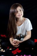 Portrait of the smiling, young woman, with the cute, colorful and beautiful dog, at black background