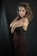 young woman posing in dark dress