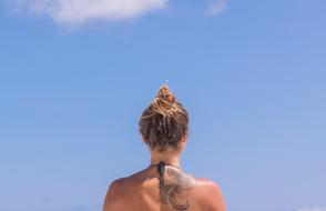 tattooed female back at blue sky