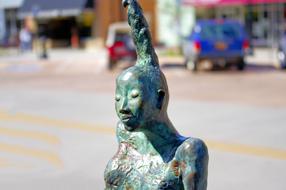 Beautiful and colorful bronze Gathering Soul sculpture, on the street, with the cars and buildings, in Colorado, USA
