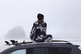 girl is sitting on the roof of the car