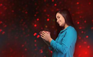 girl with coffee cup on red bokeh background