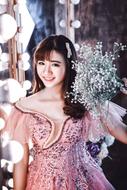 young beautiful asian woman posing with a bouquet of white flowers