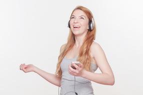 Portrait of the smiling, red haired woman in headphones, at white background