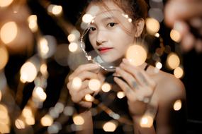 Beautiful Asian girl with make-up, among the lights, at night