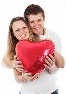 Smiling couple, with the beautiful, shiny, red heart balloon, in the hands