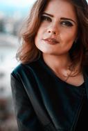 portrait of young woman with brown hair on blurred background
