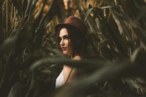 girl in a hat in the thicket