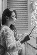 black and white photo of a girl near the window