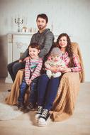 family in an armchair near the fireplace at a photo shoot