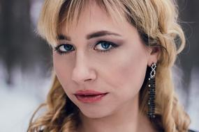 blonde with makeup and earrings, close-up