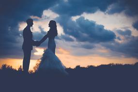 silhouettes of bride and groom at dusk