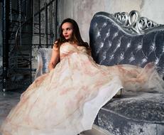 photo of a beautiful girl in a dress on a glamorous sofa