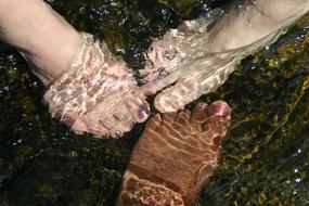 Feet with colorful nails, in the refreshing water